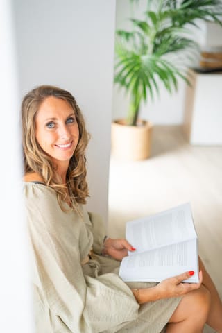 Ine De Deken met een boek in haar praktijk